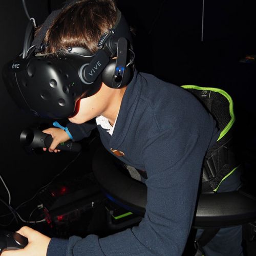 Niño jugando a conducir con gafas de realidad virtual