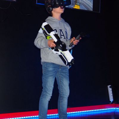 Niño con arma de plástico y gafas de realidad virtual