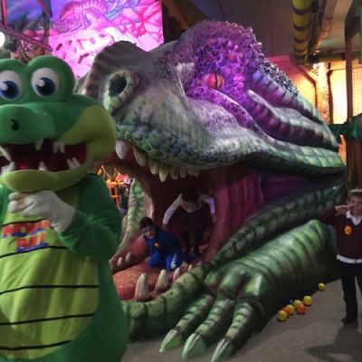 Niños jugando en dinosaurio gigante